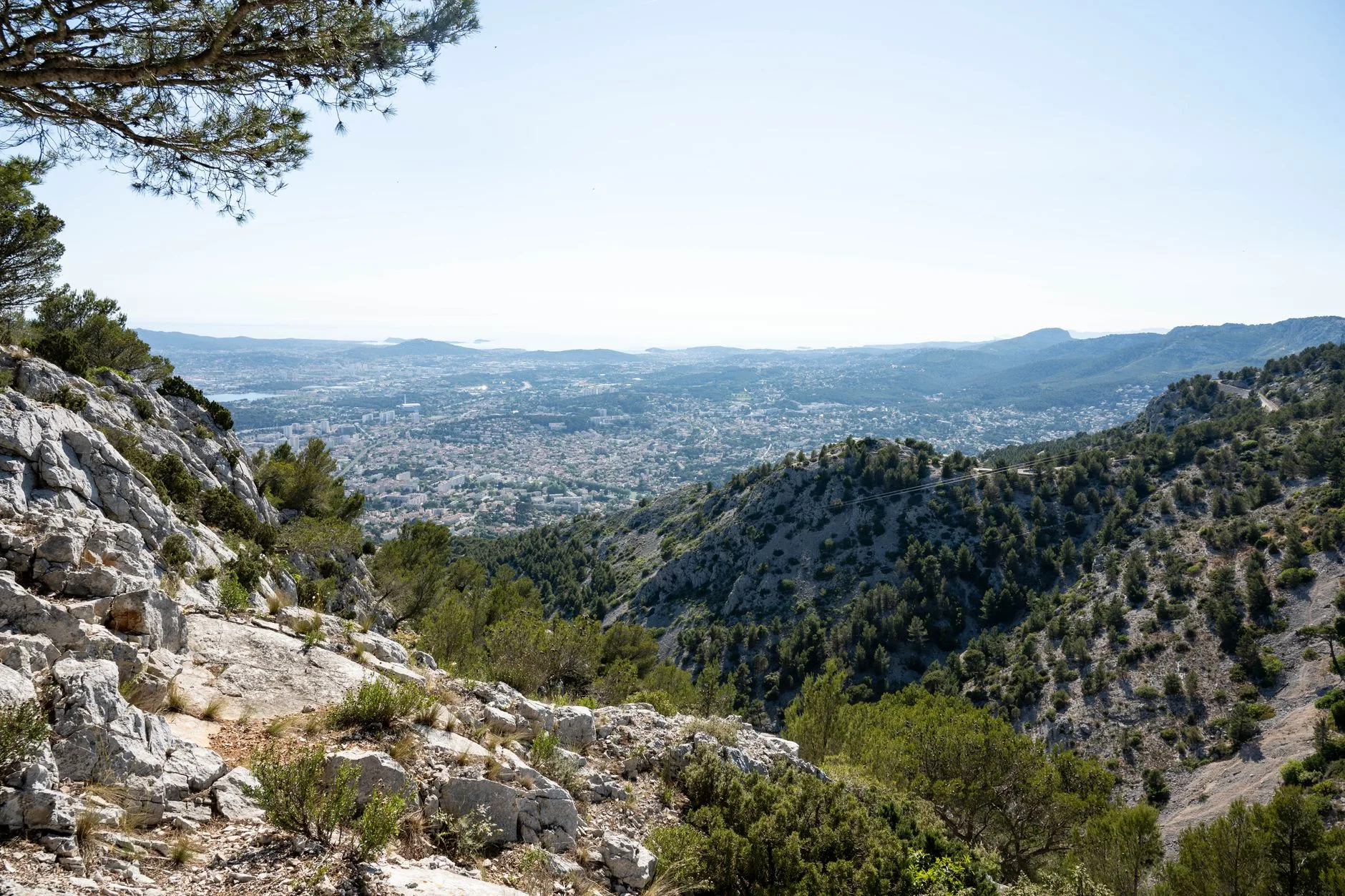 Sentier de randonnée dominant une ville côtière et la mer Méditerranée