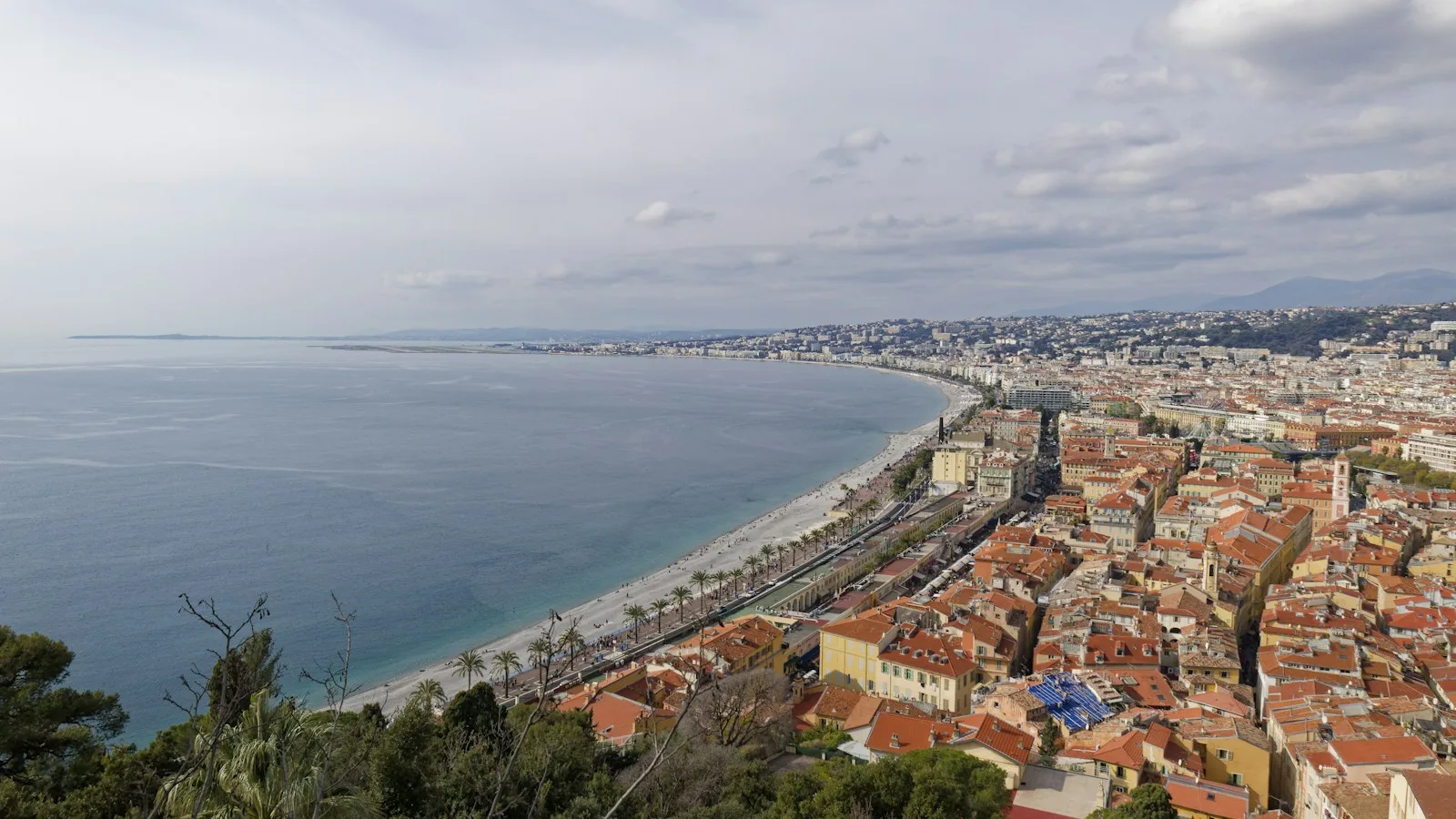 Vue sur Nice, ses toits rouges, sa longue plage et la voie ferrée qui longe la Méditerranée